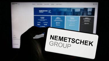 Stuttgart, Almanya - 09-10-2023: Alman yazılım şirketi Nemetschek SE 'nin logosuyla cep telefonu sahibi kişi iş sayfasının önünde ekranda. Telefon ekranına odaklan.