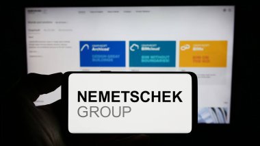 Stuttgart, Almanya - 09-10-2023: Alman yazılım şirketi Nemetschek SE 'nin logosunu elinde tutan kişi web sitesinin önünde ekranda. Telefon ekranına odaklan.