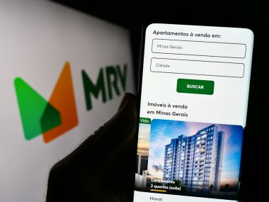 Stuttgart, Almanya - 07-26-2023: MRV Engenharia e Participacoes S.A. şirketinin web sitesi olan cep telefonu logosu önünde ekranda. Telefon ekranının merkezine odaklan.