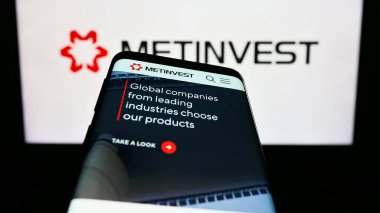 Stuttgart, Almanya - 07-27-2023: Çelik şirketi Ukraynalı Metinvest Holding LLLC 'nin web sayfalı cep telefonu logonun önünde ekranda. Telefon ekranının sol üst kısmına odaklan.