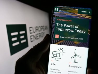 Stuttgart, Almanya - 07-27-2023: Danimarkalı yenilenebilir enerji şirketi AS 'nin web sayfası ile akıllı telefon sahibi kişi ekranda logolu. Telefon ekranının merkezine odaklan.