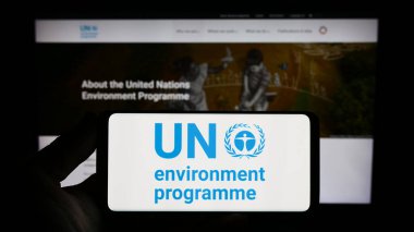 Stuttgart, Almanya - 07-27-2023: Web sitesi önünde ekranda Birleşmiş Milletler Çevre Programı (UNEP) logosu bulunan kişi. Telefon ekranına odaklan.