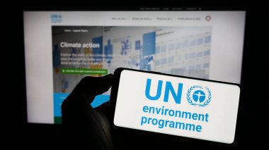 Stuttgart, Almanya - 07-27-2023: Web sayfası önünde Birleşmiş Milletler Çevre Programı (UNEP) logosu olan cep telefonu sahibi kişi. Telefon ekranına odaklan.