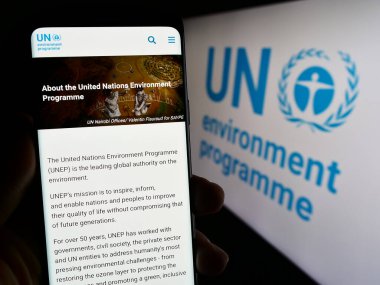 Stuttgart, Almanya - 07-27-2023: Birleşmiş Milletler Çevre Programı 'nın (UNEP) web sayfası logolu cep telefonu tutan kişi. Telefon ekranının merkezine odaklan.