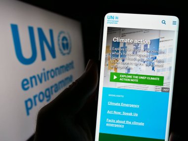 Stuttgart, Almanya - 07-27-2023: Birleşmiş Milletler Çevre Programı (UNEP) web sitesi logosu önünde cep telefonu tutan kişi. Telefon ekranının merkezine odaklan.