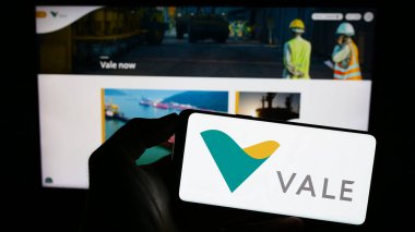 Stuttgart, Almanya - 07-27-2023: Brezilyalı maden şirketi Vale S.A. 'nın logosuyla cep telefonu sahibi kişi iş sayfasının önünde ekranda. Telefon ekranına odaklan.