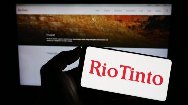 Stuttgart, Almanya - 07-27-2023: İnternet sitesi önünde üzerinde madencilik şirketi Rio Tinto Group 'un logosu bulunan akıllı telefon sahibi kişi. Telefon ekranına odaklan.