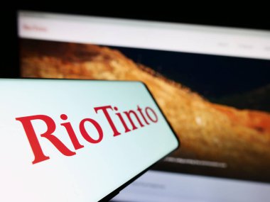 Stuttgart, Almanya - 07-27-2023: Madencilik şirketi Rio Tinto Group 'un logosunun yer aldığı cep telefonu iş sitesinin önünde ekranda. Telefon ekranının soluna odaklan.