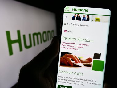 Stuttgart, Almanya - 07-28-2023: ABD 'li sağlık sigorta şirketi Humana Inc.' in web sayfası ile akıllı telefon sahibi kişi logo önünde ekranda. Telefon ekranının merkezine odaklan.