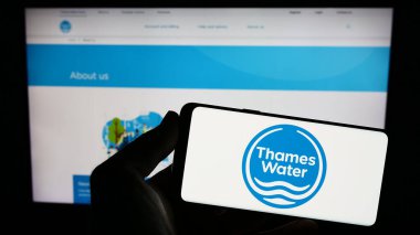 Stuttgart, Almanya - 07-28-2023: İngiliz şirketi Thames Water Utilities Limited 'in logosuna sahip akıllı telefon sahibi kişi web sitesinin önünde ekranda görülüyor. Telefon ekranına odaklan.