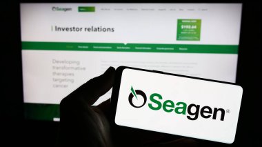 Stuttgart, Almanya - 07-28-2023: Amerikan biyoteknoloji şirketi Seagen Inc. 'in logosunun bulunduğu cep telefonu web sayfası önünde ekranda. Telefon ekranına odaklan.