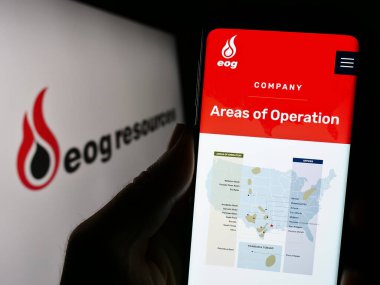 Stuttgart, Almanya - 07-28-2023: ABD 'li enerji şirketi EOG Resources Inc.' in web sitesi ile cep telefonu elinde tutan kişi logo önünde ekranda. Telefon ekranının merkezine odaklan.