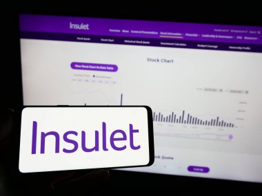Stuttgart, Germany - 07-29-2023: Person holding mobile phone with logo of US medical device company Insulet Corporation on screen in front of web page. Focus on phone display. clipart