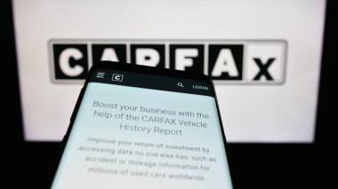 Stuttgart, Almanya - 07-29-2023: ABD 'li araç veri şirketi CARFAX Inc.' in web sitesiyle birlikte cep telefonu iş logosu önünde ekranda. Telefon ekranının sol üst kısmına odaklan.