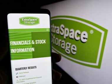 Stuttgart, Almanya - 07-29-2023: ABD 'li Extra Space Storage Inc. şirketinin web sitesi ile akıllı telefon sahibi kişi logonun önünde ekranda. Telefon ekranının merkezine odaklan.