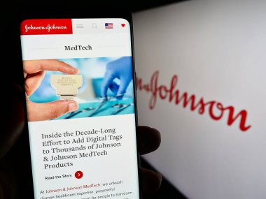 Stuttgart, Almanya - 07-29-2023: ABD 'li Johnson ve Johnson (JNJ) şirketinin web sayfası logonun önünde cep telefonu tutan kişi. Telefon ekranının merkezine odaklan.