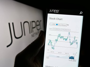 Stuttgart, Almanya - 07-29-2023: ABD 'li donanım şirketi Juniper Networks Inc.' in web sayfası olan cep telefonu logonun önünde ekranda. Telefon ekranının merkezine odaklan.