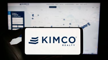 Stuttgart, Almanya - 07-30-2023: ABD 'li emlak şirketi Kimco Realty Corporation' ın logosunun bulunduğu cep telefonu web sayfası önünde ekranda. Telefon ekranına odaklan.