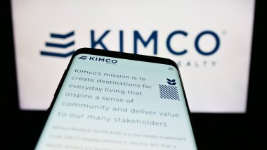 Stuttgart, Almanya - 07-30-2023: ABD 'li emlak şirketi Kimco Realty Corporation' ın web sitesiyle birlikte logo önünde ekranda. Telefon ekranının sol üst kısmına odaklan.