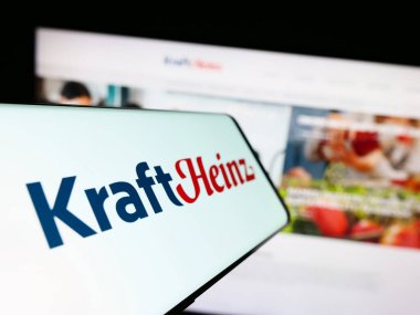 Stuttgart, Almanya - 07-30-2023: İnternet sitesinin önündeki ekranda Amerikan şirketi The Kraft Heinz Company 'nin (KHC) logosu bulunan akıllı telefon. Telefon ekranının merkez soluna odaklan.