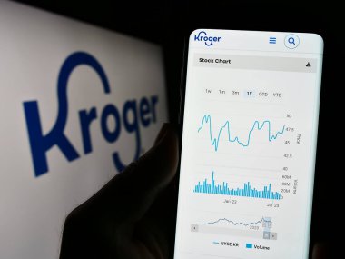 Stuttgart, Almanya - 07-30-2023: ABD 'li perakende şirketi The Kroger Company' nin web sitesi olan cep telefonu logosu önünde ekranda. Telefon ekranının merkezine odaklan.