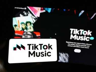 Stuttgart, Almanya - 07-30-2023: İnternet sitesi önünde ekranda yayınlanan TikTok Music logosuna sahip kişi. Telefon ekranına odaklan.