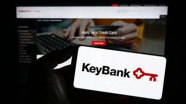 Stuttgart, Almanya - 07-30-2023: ABD 'li finans şirketi KeyCorp' un (KeyBank) logosuyla cep telefonu sahibi kişi iş sayfası önünde ekranda. Telefon ekranına odaklan.