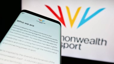 Stuttgart, Germany - 07-30-2023: Smartphone with website of organisation Commonwealth Games Federation (CGF) on screen in front of logo. Focus on top-left of phone display. clipart