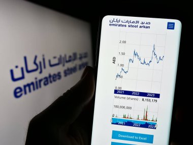Stuttgart, Almanya - 07-30-2023: Logo önünde Emirates Steel Arkan (BAE) şirketinin web sayfası olan akıllı telefonu elinde tutan kişi. Telefon ekranının merkezine odaklan.