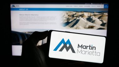Stuttgart, Almanya - 07-31-2023: İnternet sitesinin önünde ekranda Martin Marietta Material Inc. 'in logosunun bulunduğu akıllı telefon sahibi kişi. Telefon ekranına odaklan.
