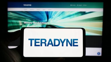 Stuttgart, Almanya - 08-01-2023: ABD 'li test ekipman şirketi Teradyne Inc.' in logosuyla cep telefonu sahibi kişi iş sayfasının önünde ekranda. Telefon ekranına odaklan.