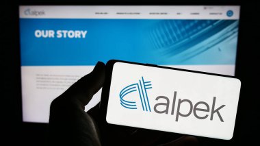 Stuttgart, Almanya - 08-01-2023: Meksikalı kimya şirketi Alpek S.A.B. 'nin logosunu taşıyan kişi de C.V. web sitesinin önünde ekranda. Telefon ekranına odaklan.