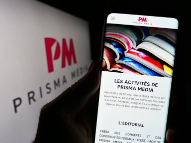 Stuttgart, Almanya - 08-01-2023: Fransız yayıncılık şirketi Prisma Media 'nın web sayfası ile akıllı telefon sahibi kişi logo önünde ekranda. Telefon ekranının merkezine odaklan.