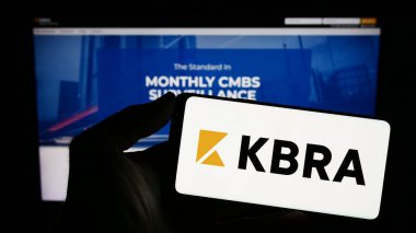 Stuttgart, Almanya - 08-01-2023: İnternet sayfası önünde ekranda Kroll Bond Derecelendirme Ajansı (KBRA) logosunun bulunduğu cep telefonu sahibi kişi. Telefon ekranına odaklan.