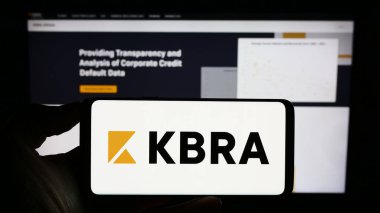 Stuttgart, Almanya - 08-01-2023: İnternet sayfası önünde ekranda Kroll Bond Derecelendirme Ajansı (KBRA) logosunun bulunduğu cep telefonu sahibi kişi. Telefon ekranına odaklan.