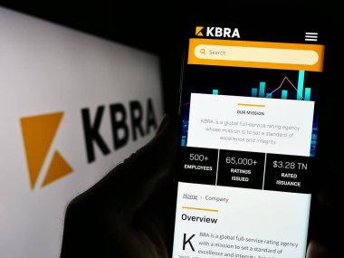 Stuttgart, Almanya - 08-01-2023: ABD 'li Kroll Bond Derecelendirme Ajansı LLC' nin (KBRA) web sitesi ile cep telefonu tutan kişi logolu ekranda. Telefon ekranının merkezine odaklan.