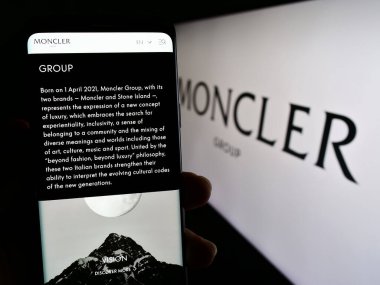 Stuttgart, Almanya - 08-02-2023: İtalyan moda şirketi Moncler SpA 'nın web sayfası olan cep telefonu logosu önünde ekranda. Telefon ekranının merkezine odaklan.