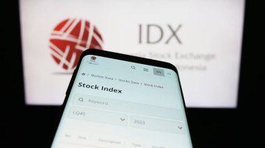 Stuttgart, Germany - 08-02-2023: Mobile phone with webpage of financial market Indonesia Stock Exchange (IDX) on screen in front of logo. Focus on top-left of phone display. clipart