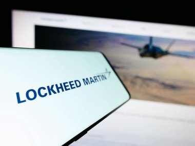 Stuttgart, Almanya - 08-02-2023: Amerikan savunma şirketi Lockheed Martin Corporation 'ın logosu olan cep telefonu web sitesinin önünde ekranda. Telefon ekranının merkez soluna odaklan.