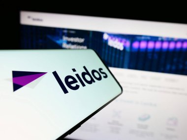 Stuttgart, Almanya - 08-02-2023: Amerikan savunma şirketi Leidos Inc. 'in logosuna sahip akıllı telefon iş dünyasının web sitesinin önünde ekranda. Telefon ekranının merkez soluna odaklan.