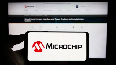 Stuttgart, Almanya - 08-04-2023: Yarı iletken şirket Microchip Technology Inc. 'in logosuna sahip cep telefonu web sayfası önünde ekranda. Telefon ekranına odaklan.