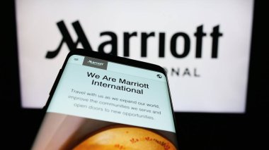 Stuttgart, Germany - 08-04-2023: Smartphone with website of US hotel company Marriott International Inc. on screen in front of business logo. Focus on top-left of phone display. clipart