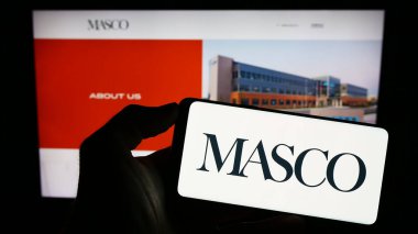 Stuttgart, Almanya - 08-04-2023: Amerikan ev geliştirme şirketi Masco Corporation 'ın logosunun bulunduğu cep telefonu web sayfası önünde ekranda. Telefon ekranına odaklan.