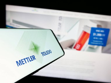 Stuttgart, Germany - 08-04-2023: Cellphone with logo of company Mettler-Toledo International Inc. on screen in front of business website. Focus on center of phone display. clipart