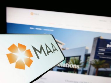 Stuttgart, Almanya - 08-05-2023: Orta Amerika Apartman Toplulukları A.Ş. (MAA) logosu olan akıllı telefon şirket web sitesinin önünde ekranda. Telefon ekranının merkez soluna odaklan.