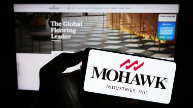 Stuttgart, Almanya - 08-05-2023: ABD 'li döşeme şirketi Mohawk Industries Inc.' in logosunu taşıyan kişi web sitesinin önünde ekranda. Telefon ekranına odaklan.