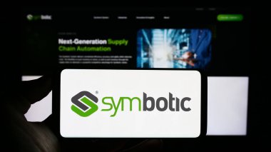 Stuttgart, Almanya - 08-05-2023: Üzerinde ABD 'li robotik depo şirketi Sembotik A.Ş. logosu olan cep telefonu sahibi kişi iş sayfasının önünde ekranda. Telefon ekranına odaklan.