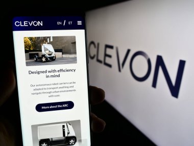 Stuttgart, Almanya - 08-05-2023: Estiyonyalı otonom araç şirketi Clevon AS 'in web sayfası ile akıllı telefon sahibi kişi logolu ekranda. Telefon ekranının merkezine odaklan.