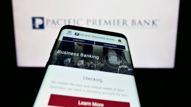 Stuttgart, Germany - 08-05-2023: Smartphone with website of US financial company Pacific Premier Bancorp Inc. on screen in front of logo. Focus on top-left of phone display. clipart