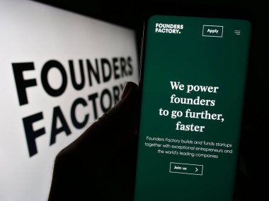 Stuttgart, Almanya - 08-05-2023: British Company Founders Factory Ltd. 'nin web sayfası logo önünde duran kişi. Telefon ekranının merkezine odaklan.